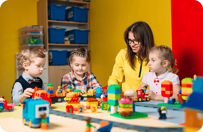 Teacher sitting with children and playing with colorful building blocks.